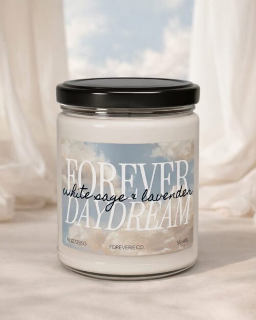 Forever Daydream soy candle by Foreverie with white sage and lavender scent, styled against soft linen drapery and sky backdrop.