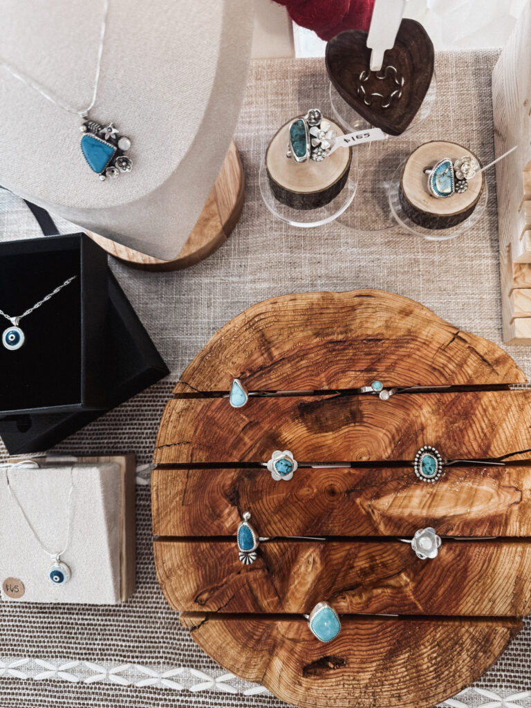 Handmade sterling silver turquoise jewelry displayed on natural wood with linen textures