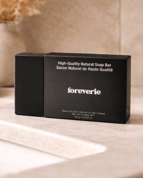 Foreverie matte black natural soap bar box on neutral stone bathroom countertop with soft warm lighting