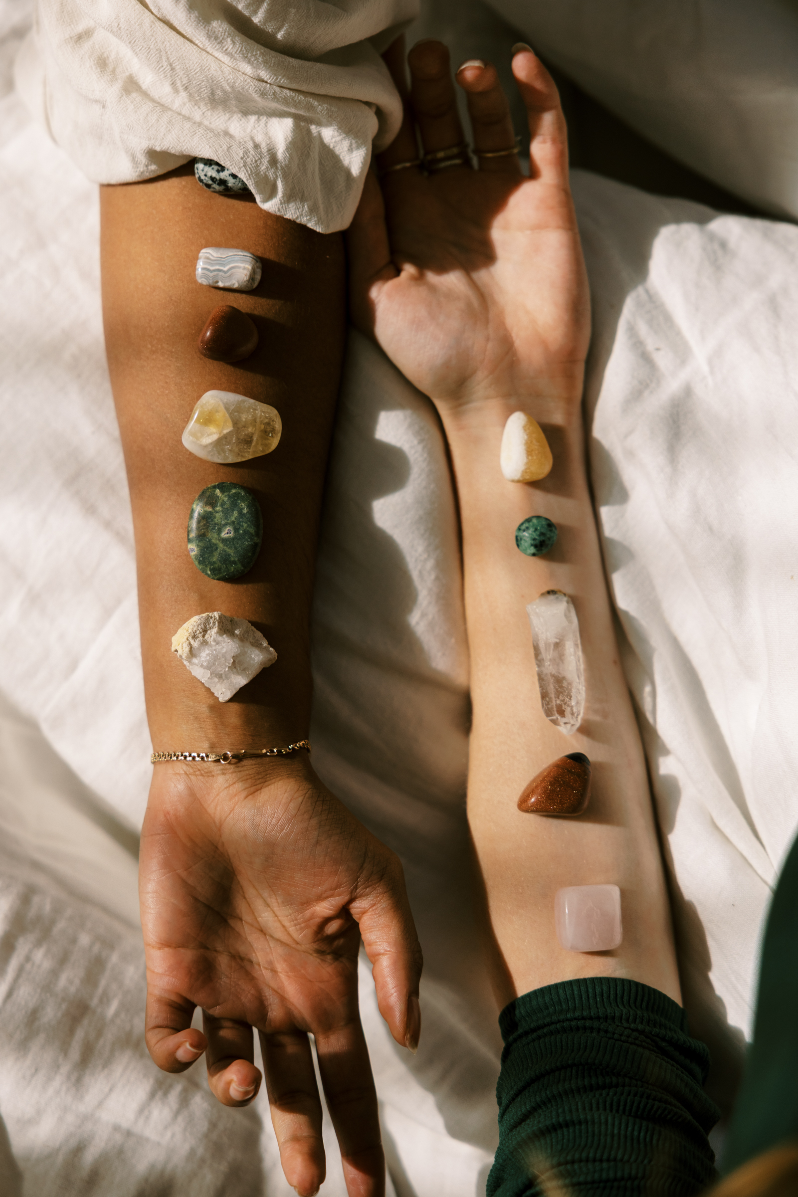 Two people with crystals placed along their arms during an intentional group wellness experience focused on connection and energy