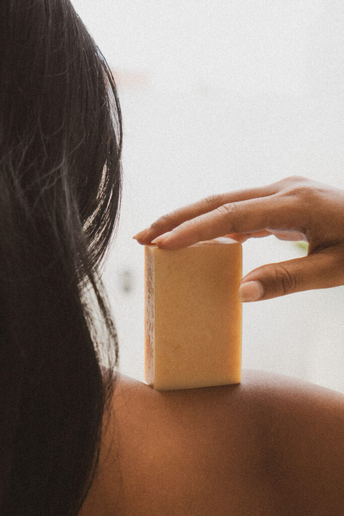 Natural bar soap held against the shoulder as part of a calm, intentional beauty routine.