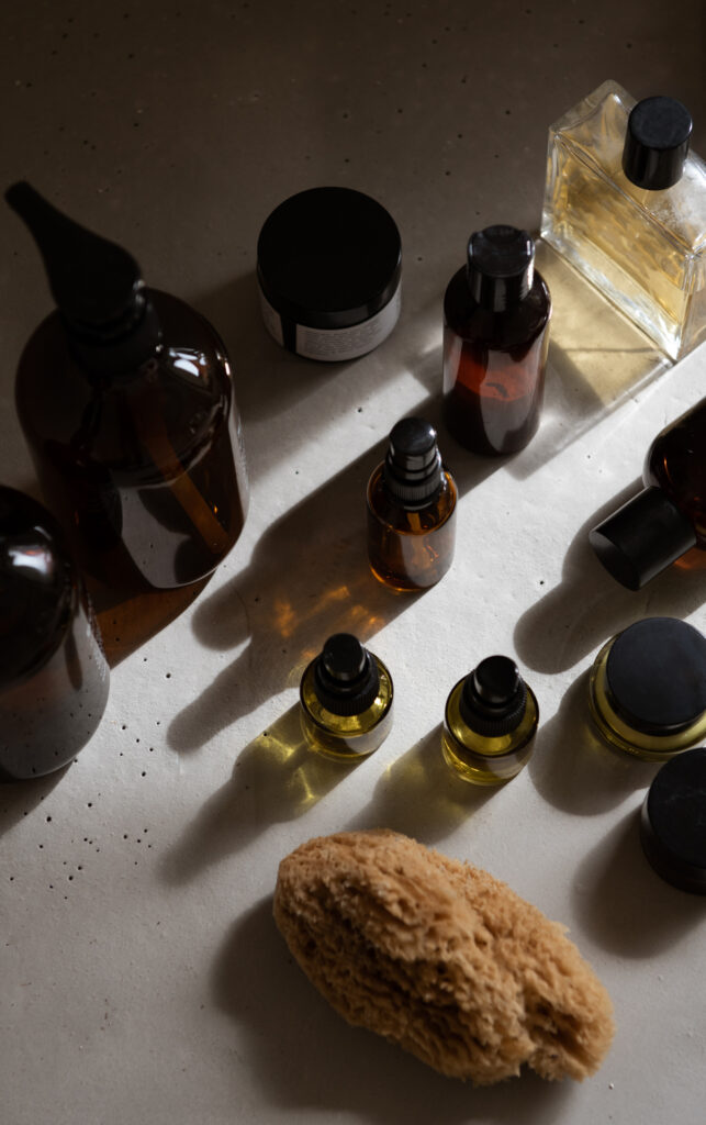 Minimal skincare and beauty essentials arranged on a marble vanity in soft natural light.