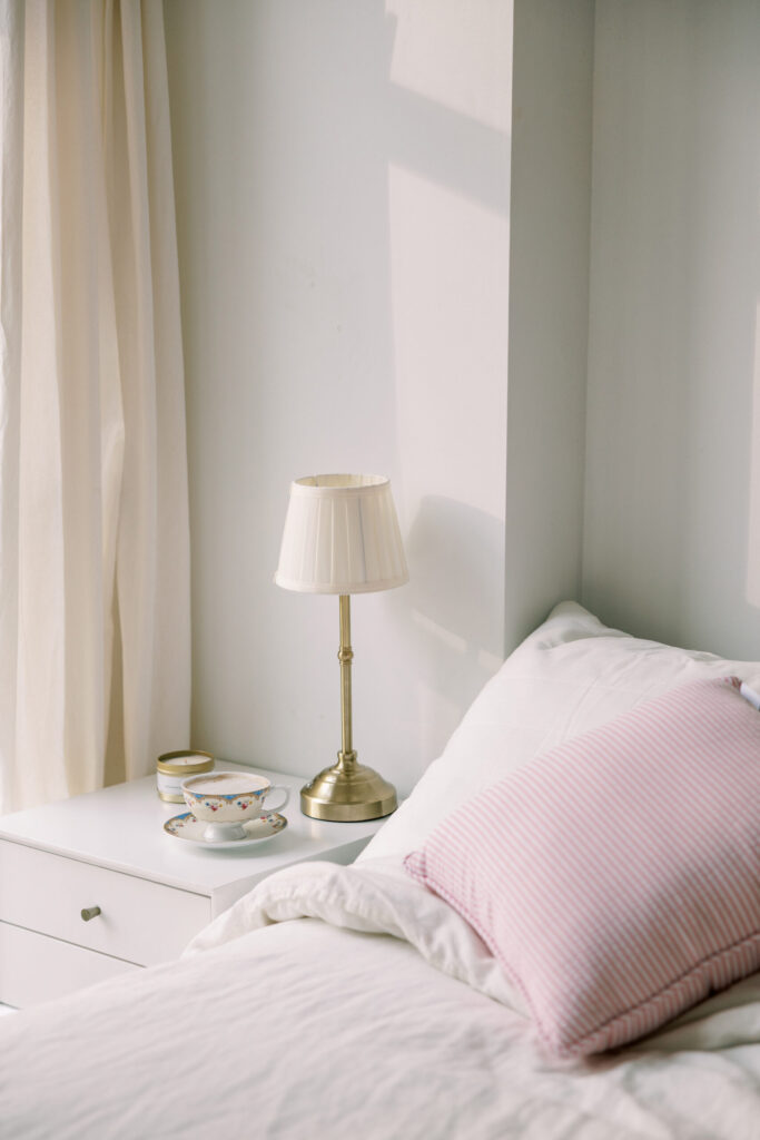 Tea cup and bedside table lit by soft morning sunlight